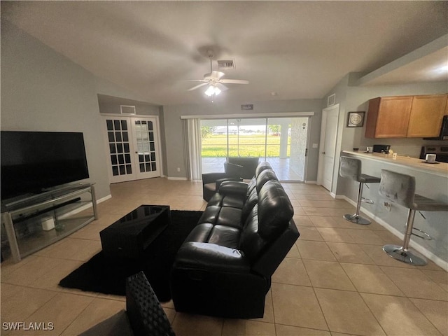 living room with light tile patterned floors, baseboards, a ceiling fan, and lofted ceiling