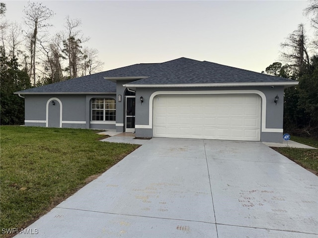 ranch-style house with a garage and a yard