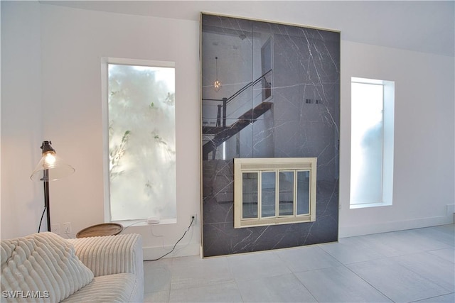 living room with tile patterned flooring and a high end fireplace