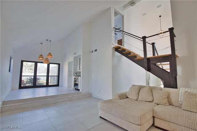 unfurnished living room with high vaulted ceiling and light tile patterned floors