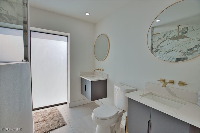 bathroom featuring vanity, a shower, tile patterned floors, and toilet