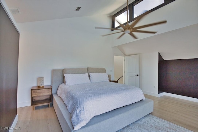 bedroom with vaulted ceiling, ceiling fan, and light wood-type flooring