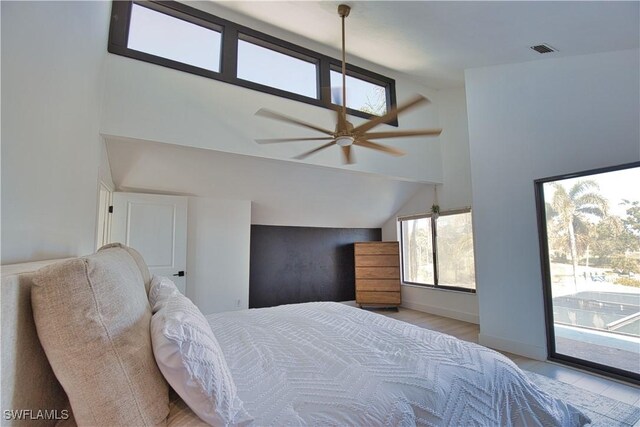 bedroom with access to exterior, high vaulted ceiling, and light hardwood / wood-style flooring