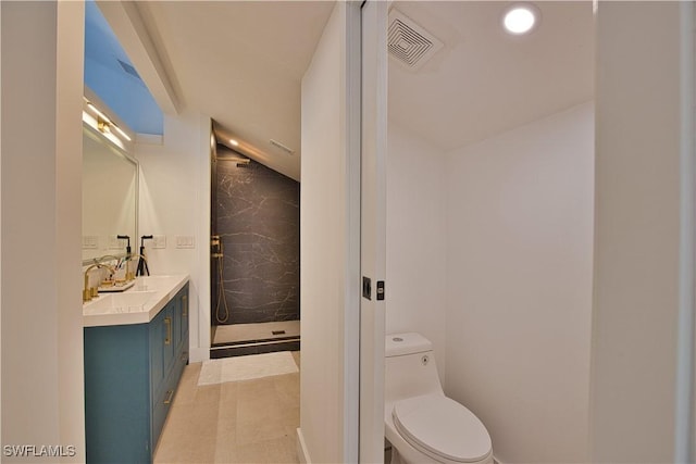 bathroom with vanity, a tile shower, and toilet