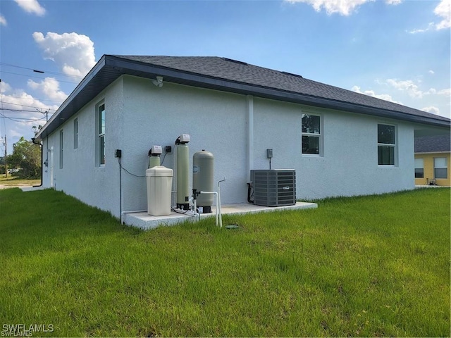 back of house with cooling unit and a yard