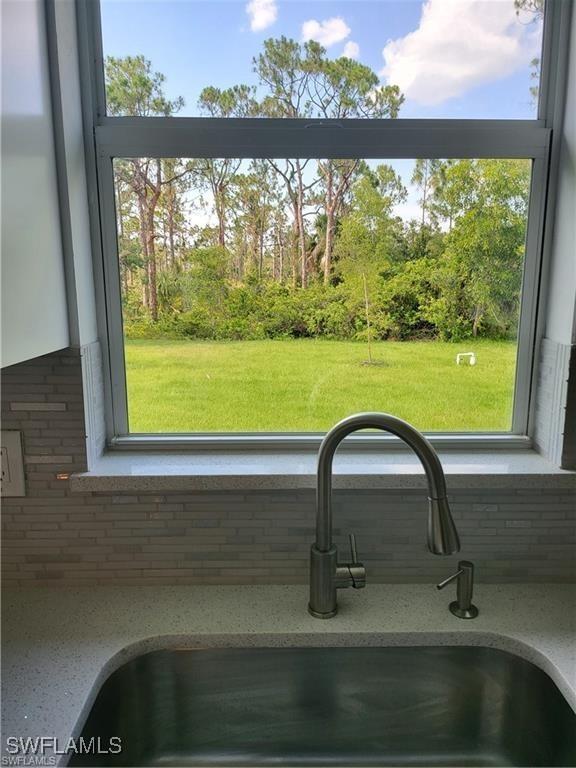 details featuring tasteful backsplash and sink