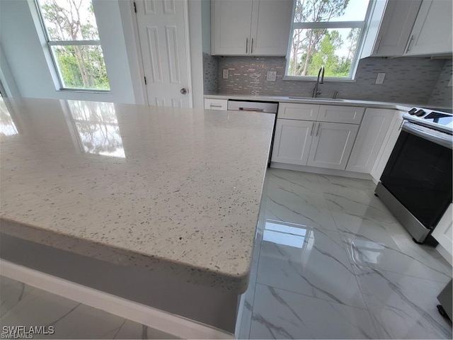 kitchen featuring sink, light stone counters, white cabinetry, stainless steel electric range oven, and tasteful backsplash