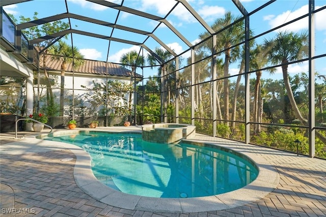 view of pool with an in ground hot tub, a patio, and glass enclosure