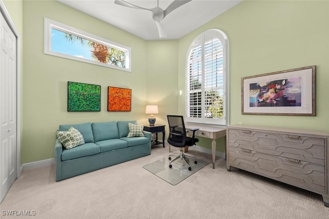 home office with ceiling fan, a towering ceiling, light colored carpet, and a healthy amount of sunlight