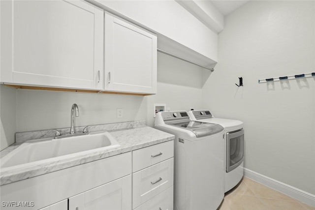 laundry area with sink, washer and clothes dryer, cabinets, and light tile patterned flooring