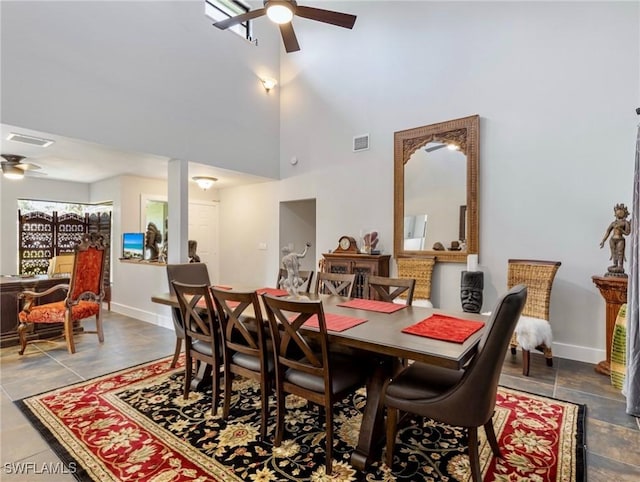 dining space with ceiling fan and a high ceiling