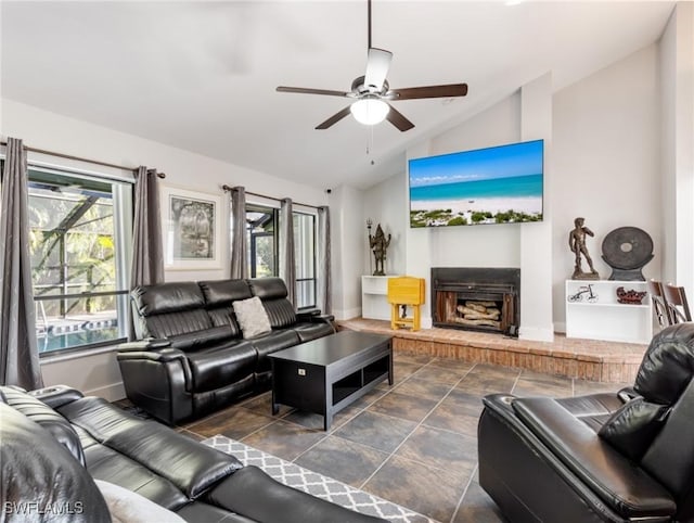 living room with ceiling fan, lofted ceiling, a wealth of natural light, and a fireplace