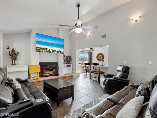 tiled living room with ceiling fan and high vaulted ceiling