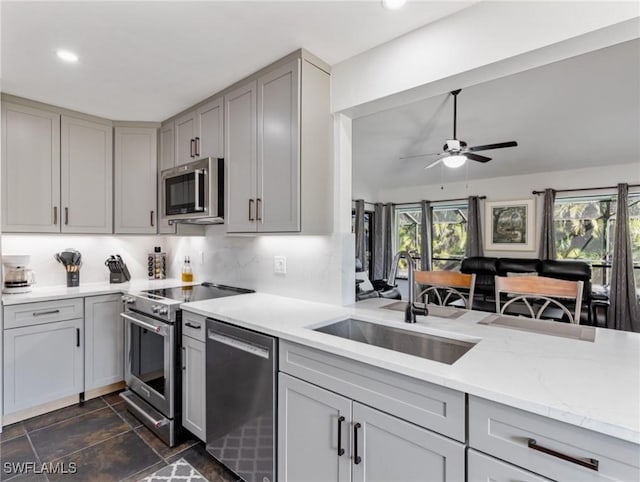 kitchen with sink, decorative backsplash, gray cabinets, and appliances with stainless steel finishes