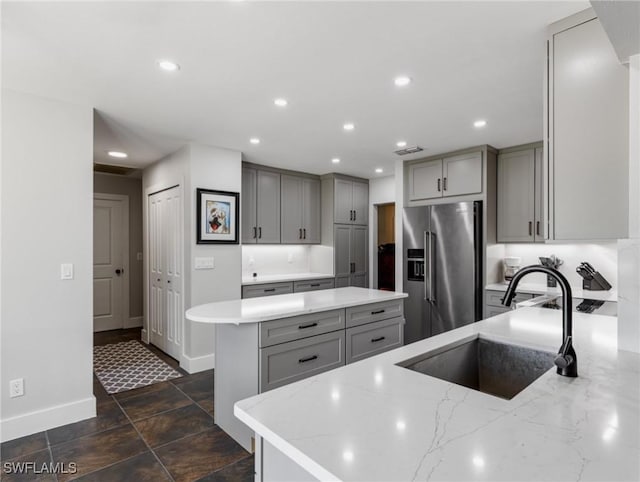 kitchen featuring gray cabinets, light stone countertops, sink, and high end refrigerator