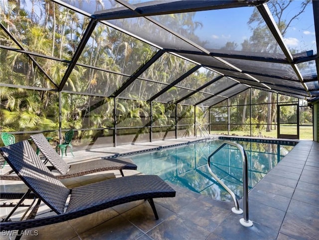 view of pool featuring glass enclosure and a patio area