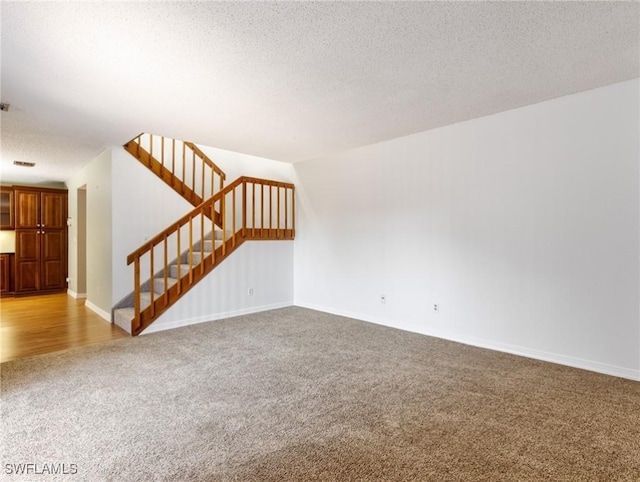 unfurnished living room featuring carpet and a textured ceiling