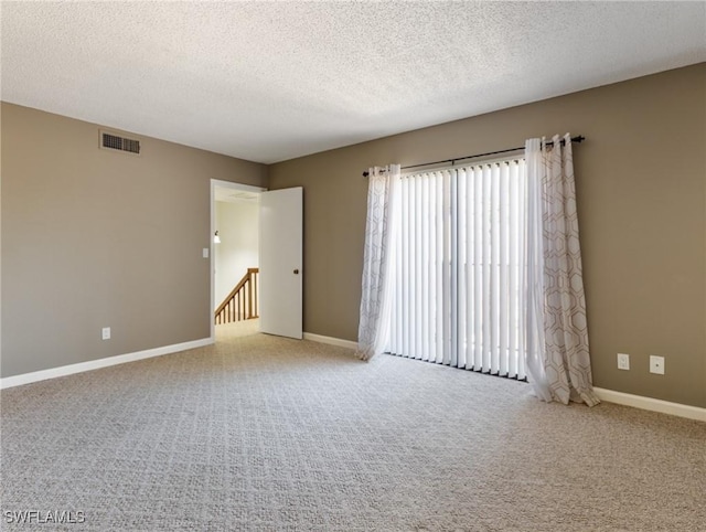 spare room with carpet and a textured ceiling