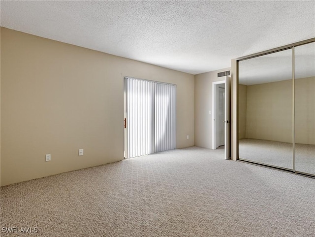 empty room with carpet and a textured ceiling