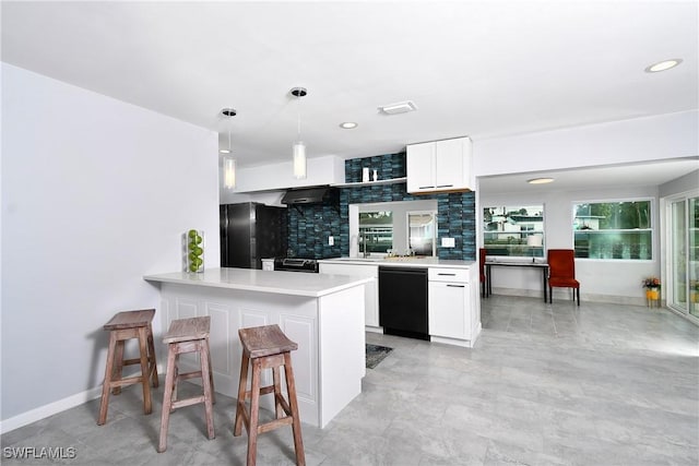 kitchen featuring pendant lighting, white cabinetry, black appliances, decorative backsplash, and kitchen peninsula