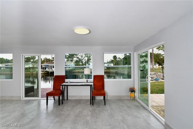 sunroom / solarium with a water view