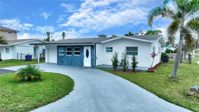 ranch-style house featuring a carport, central AC unit, and a front lawn