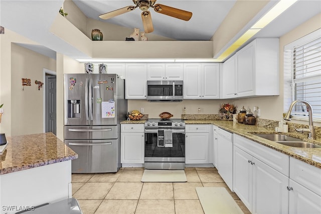 kitchen featuring appliances with stainless steel finishes, white cabinetry, light tile patterned floors, and sink