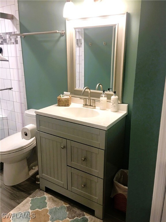 16881 Davis Rd Unit 712, Fort Myers, FL 33908 - bathroom featuring vanity, hardwood / wood-style flooring, and toilet