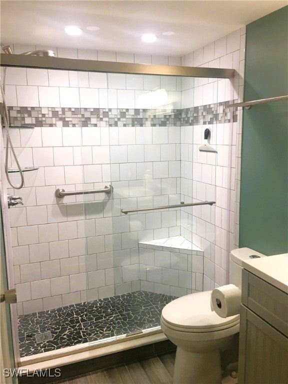 16881 Davis Rd Unit 712, Fort Myers, FL 33908 - bathroom featuring vanity, hardwood / wood-style flooring, a shower with shower door, and toilet
