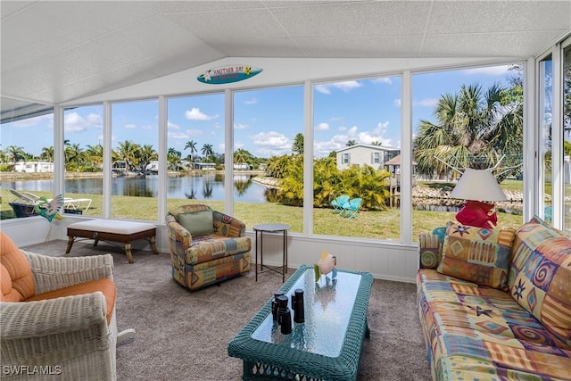 sunroom with vaulted ceiling and a water view