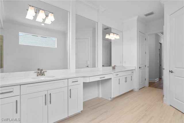 bathroom featuring hardwood / wood-style flooring, ornamental molding, and vanity