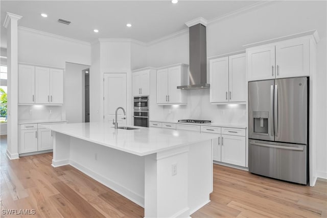 kitchen with white cabinetry, stainless steel appliances, and wall chimney range hood