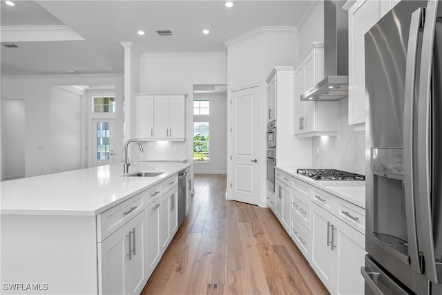 kitchen featuring sink, white cabinetry, stainless steel appliances, an island with sink, and wall chimney exhaust hood