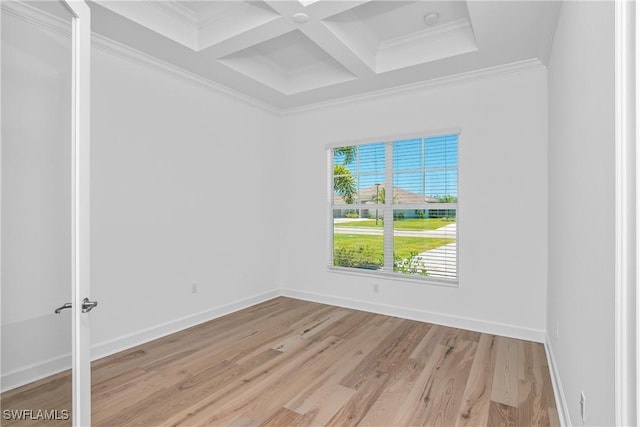 spare room with beamed ceiling, ornamental molding, coffered ceiling, and light hardwood / wood-style flooring