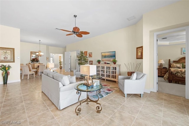 living room with ceiling fan with notable chandelier and light tile patterned floors