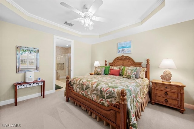 bedroom featuring ensuite bathroom, light carpet, ornamental molding, a raised ceiling, and ceiling fan