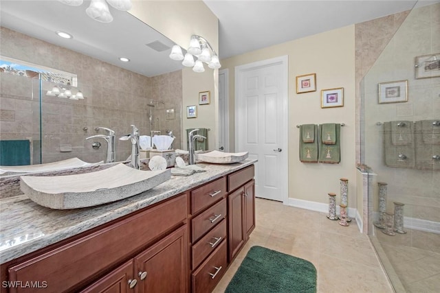 bathroom featuring tile patterned floors, vanity, and a shower with door