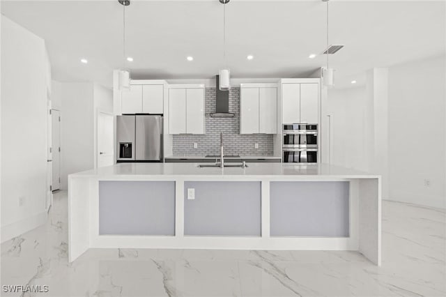 kitchen with white cabinetry, pendant lighting, a large island with sink, and appliances with stainless steel finishes