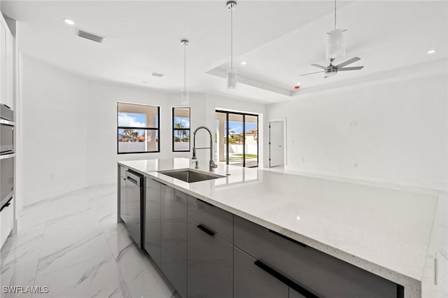 kitchen featuring sink, appliances with stainless steel finishes, a tray ceiling, gray cabinets, and pendant lighting