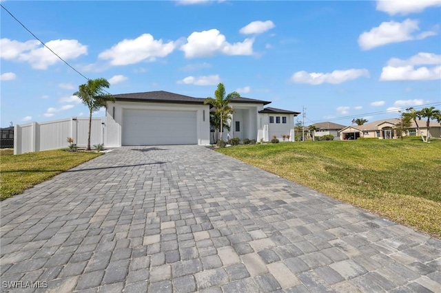 single story home featuring a garage, fence, decorative driveway, stucco siding, and a front lawn