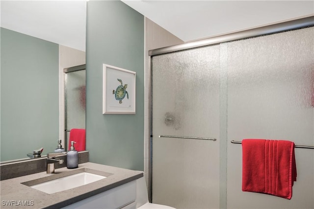 bathroom featuring vanity, toilet, and a shower with door