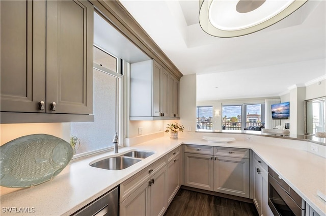 kitchen with stainless steel microwave, dark hardwood / wood-style flooring, kitchen peninsula, and sink