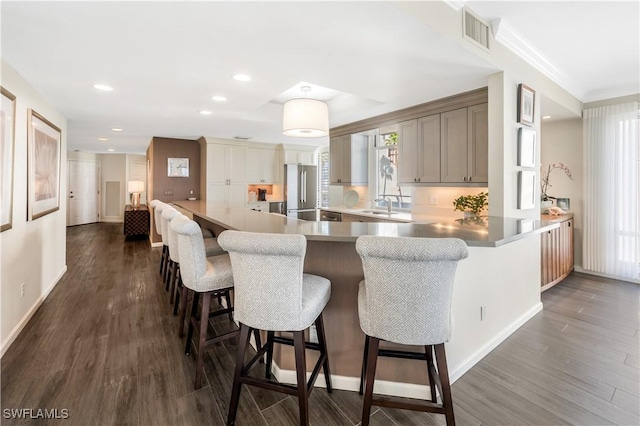 kitchen featuring sink, high end fridge, a breakfast bar, and kitchen peninsula