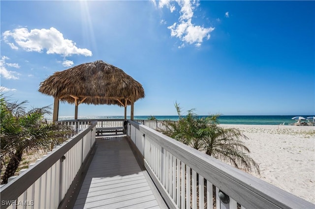 view of home's community featuring a gazebo, a water view, and a beach view