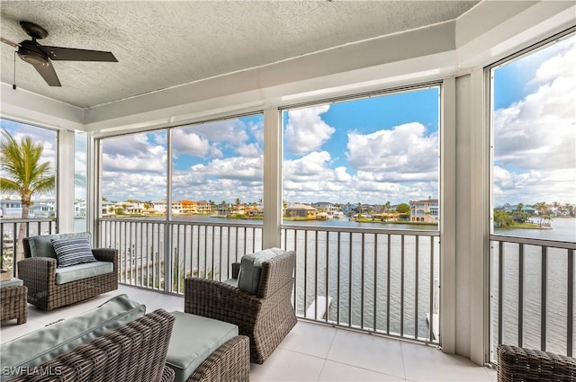 sunroom featuring a water view and ceiling fan