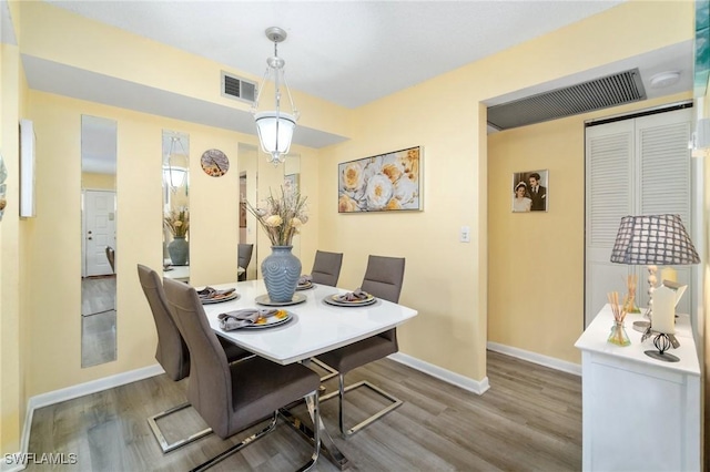 dining space featuring visible vents, wood finished floors, and baseboards