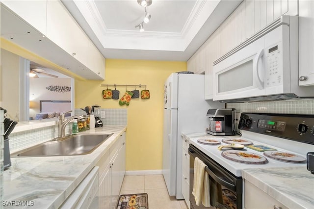 kitchen featuring white appliances, a sink, ornamental molding, a raised ceiling, and backsplash