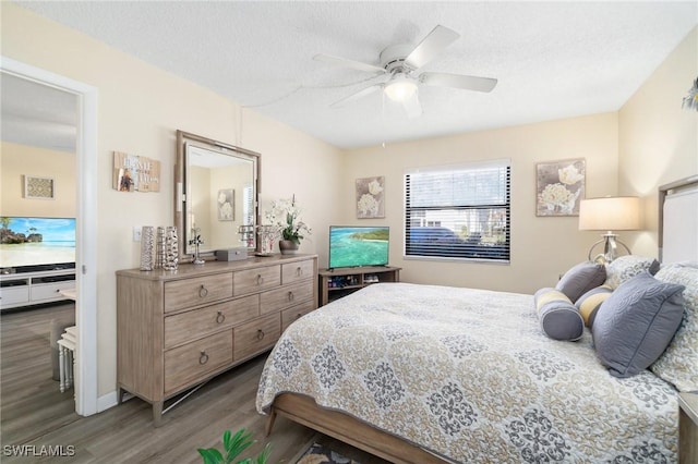 bedroom featuring visible vents, a textured ceiling, ceiling fan, and wood finished floors