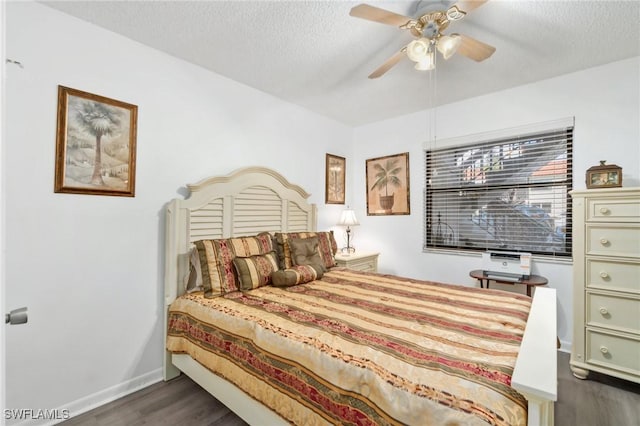 bedroom with ceiling fan, baseboards, a textured ceiling, and dark wood finished floors