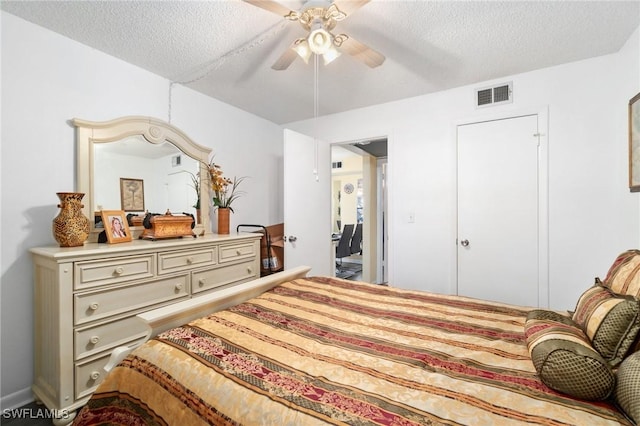 bedroom with ceiling fan, visible vents, and a textured ceiling